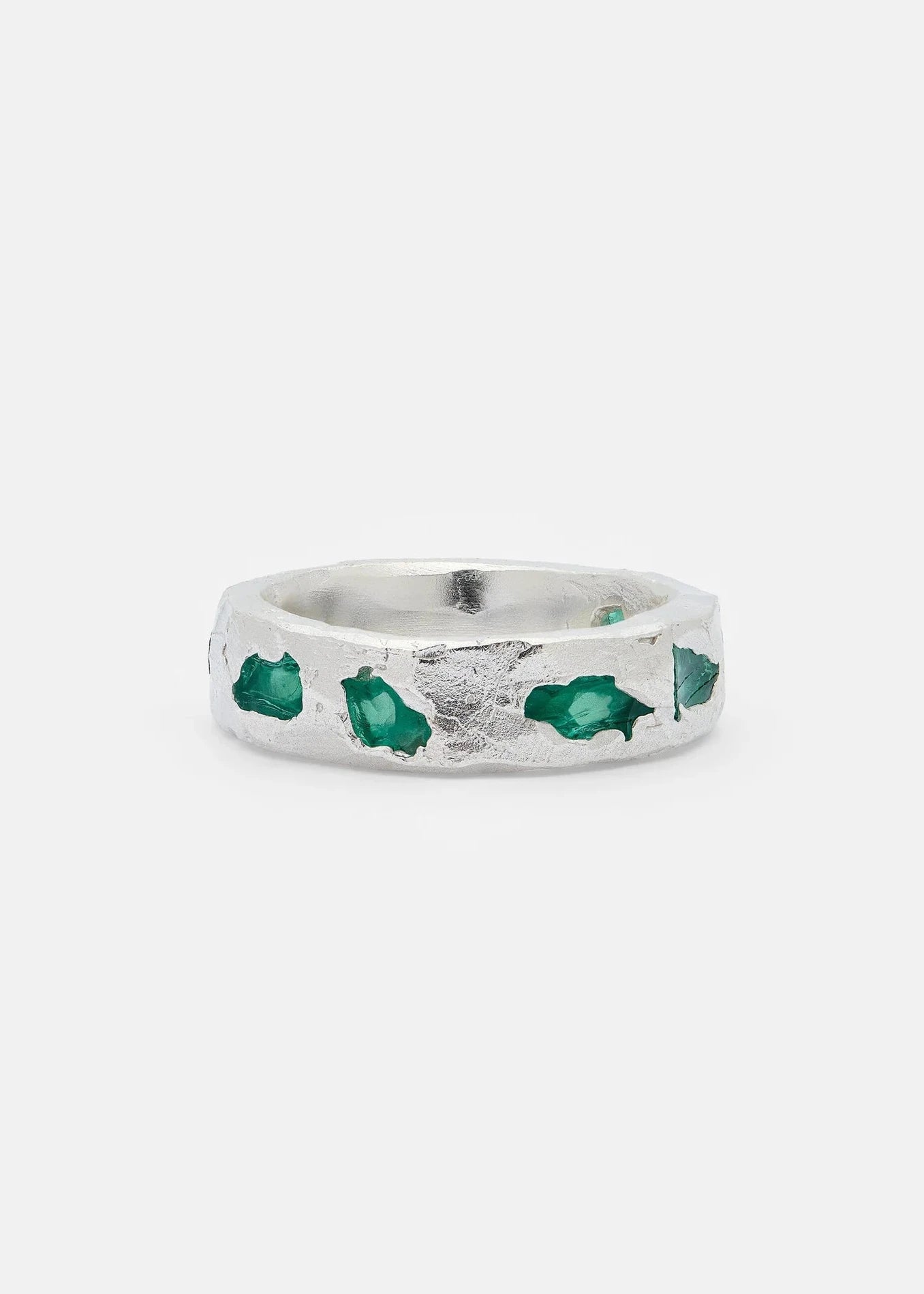 Silver ring with green gemstones on a white background