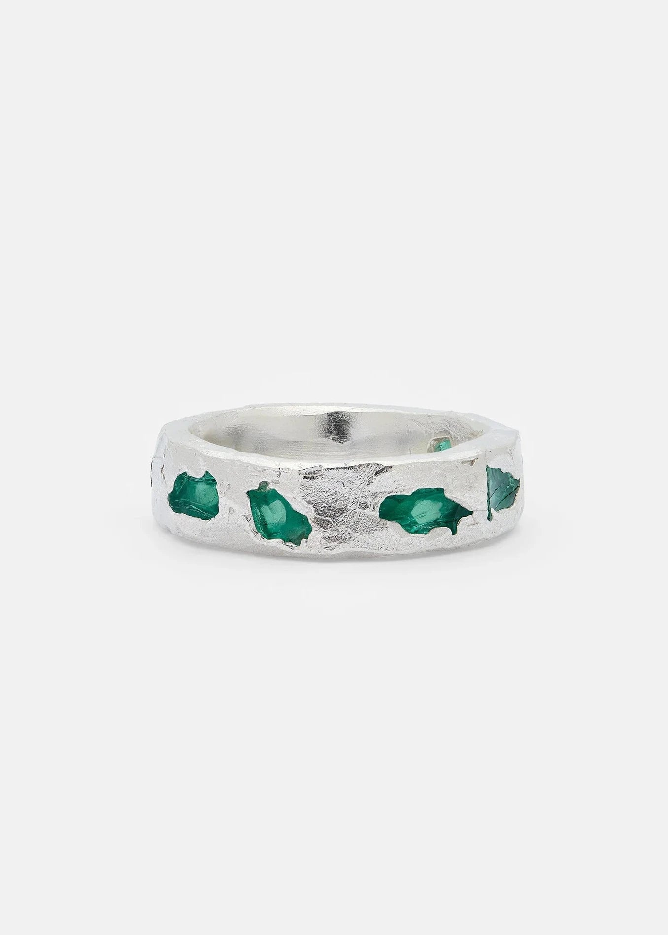 Silver ring with green gemstones on a white background