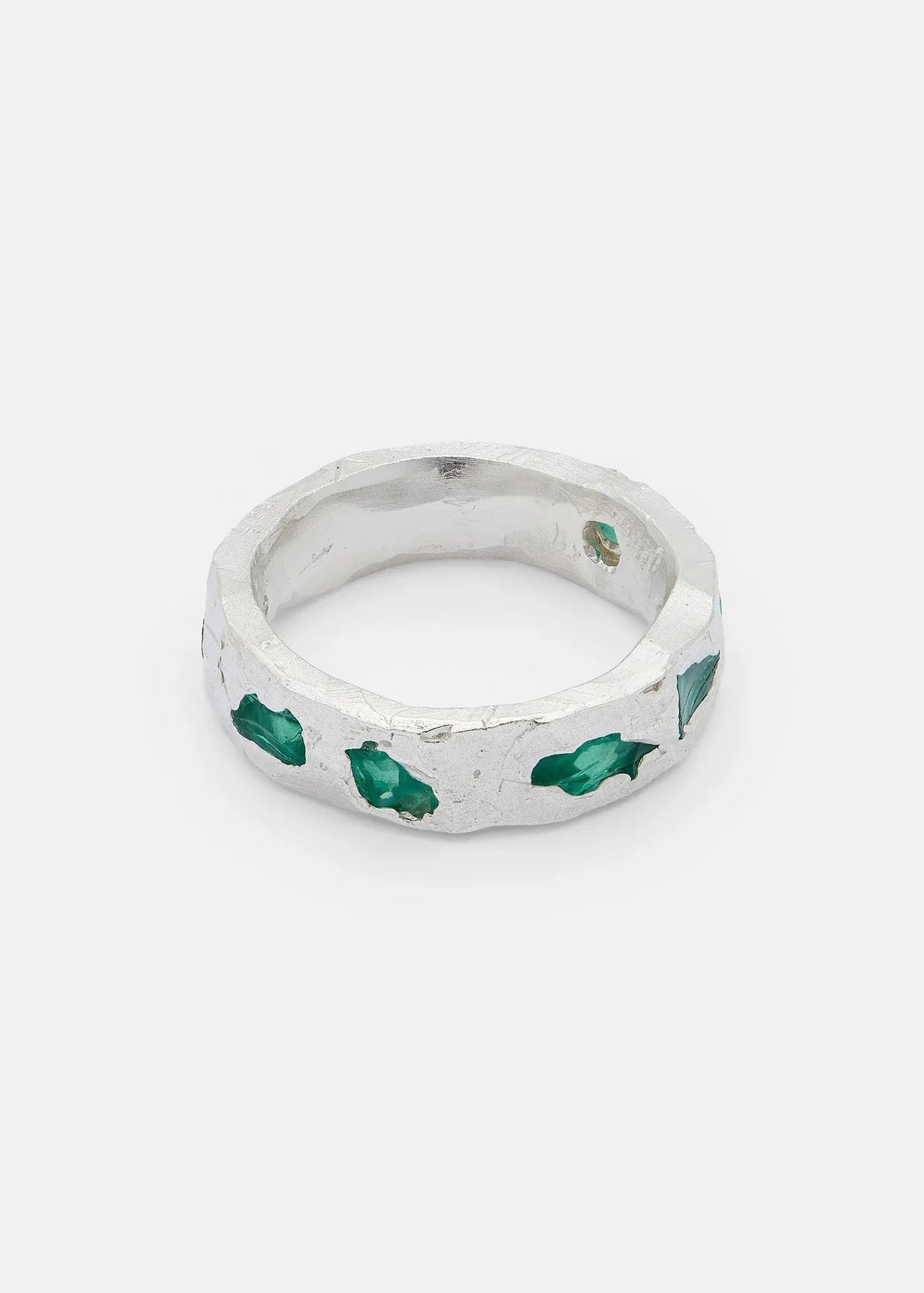 Silver ring with green gemstones on a white background