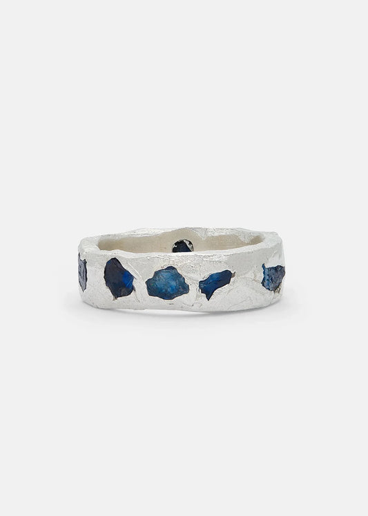 Silver ring with blue gemstones on a white background