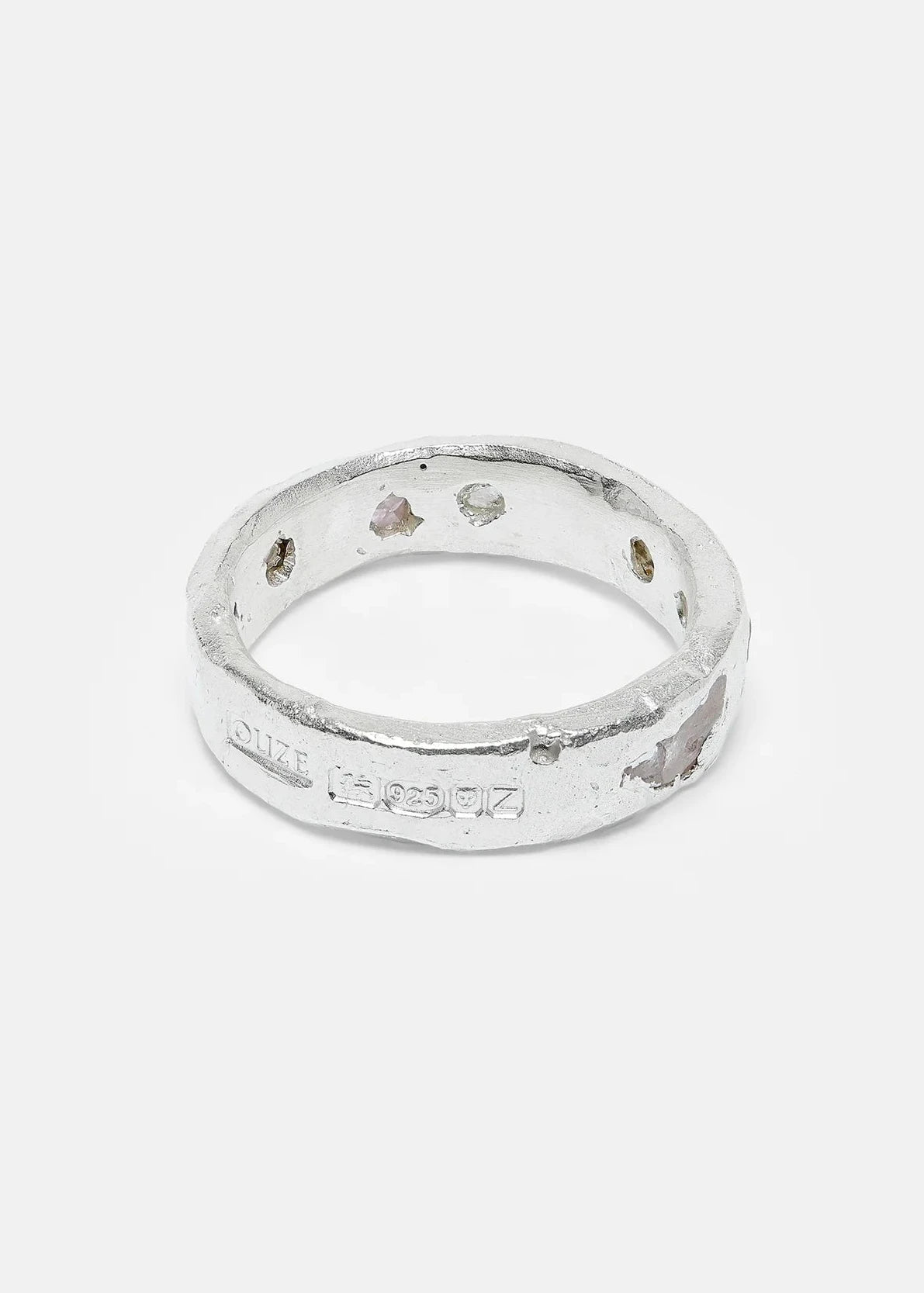 Silver ring with engraved text on a white background