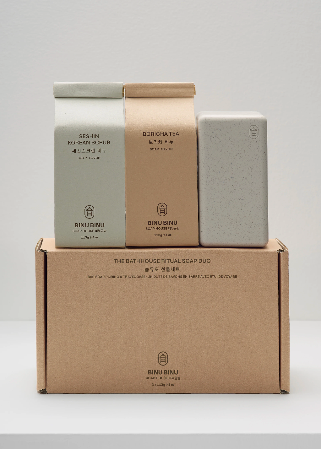 Three soap bars and a cardboard box on a white background