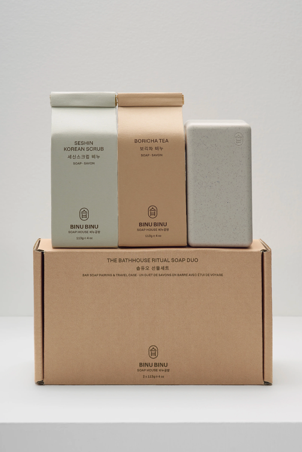 Three soap bars and a cardboard box on a white background