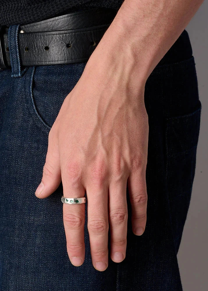 Hand wearing a ring with a gray background
