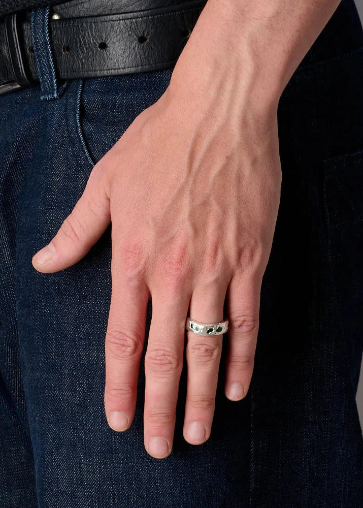 Hand wearing a ring with a gray background