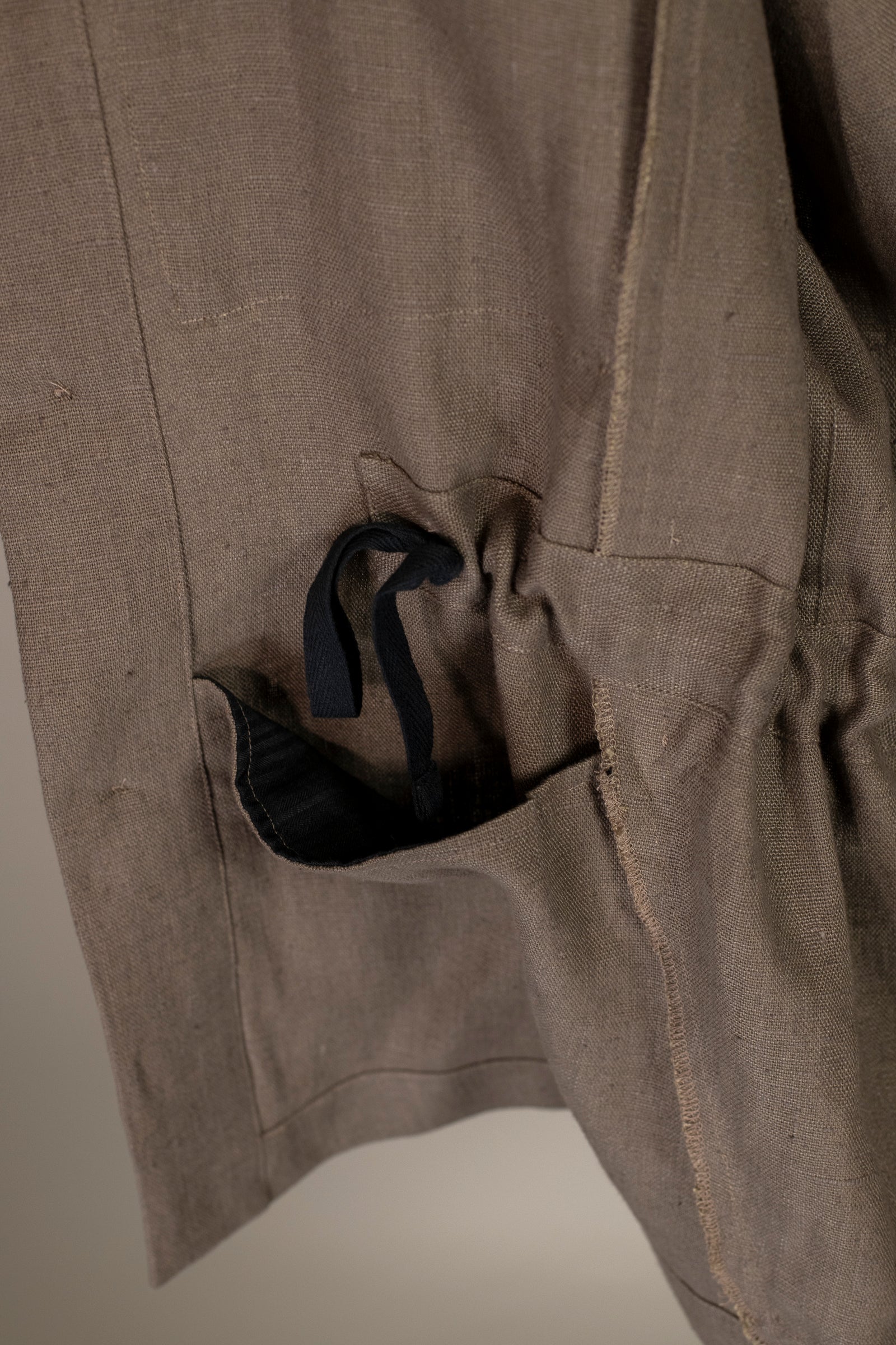 Close up on pocket and drawstring on Wanze men's natural linen field jacket in brown